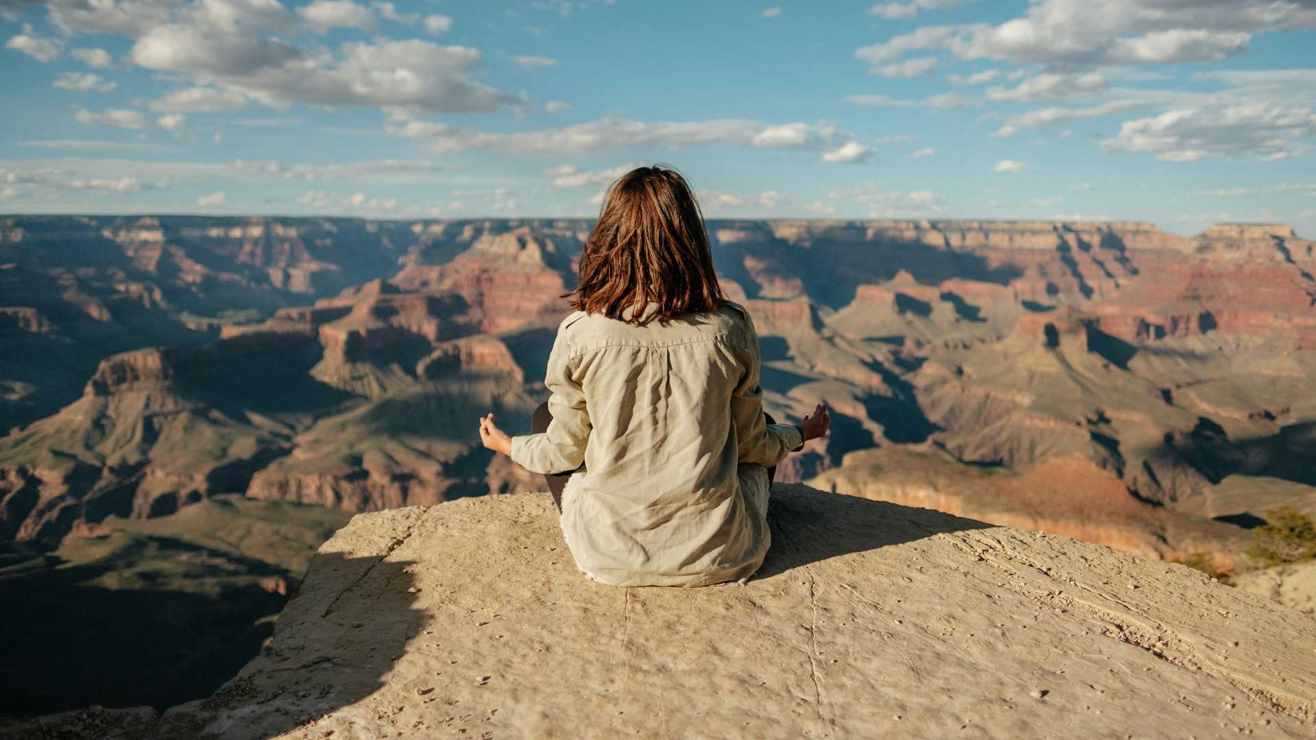 Paysage montagneux avec une femme méditant de dos